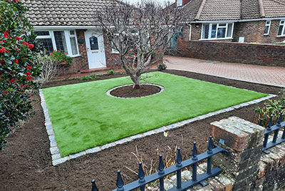 Artificial grass with granite edging and acre tree in the middle
