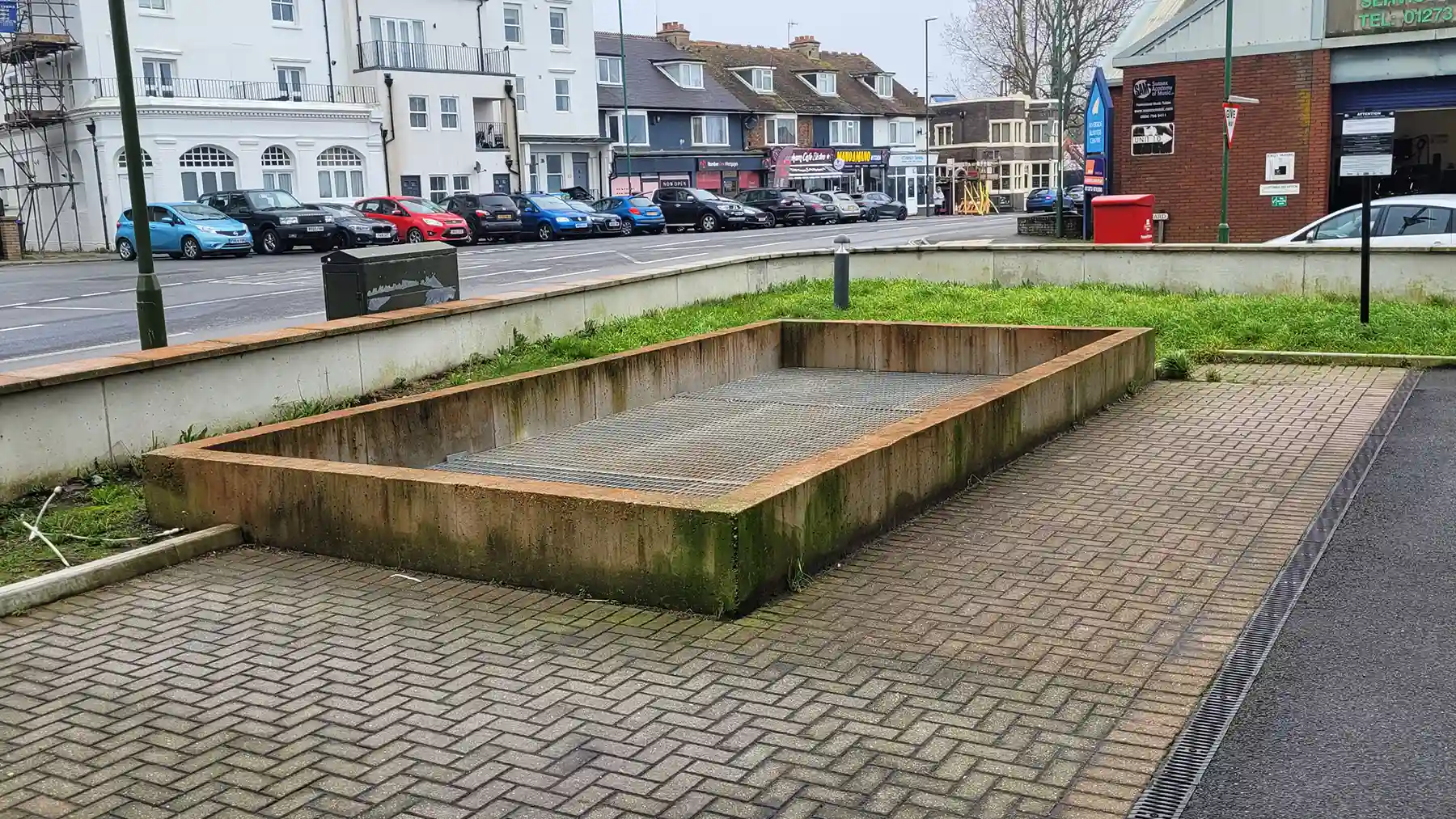 Block paced area with grills over an underground car park.