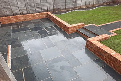 Old farmhouse brick wall around a Brazilian slate patio