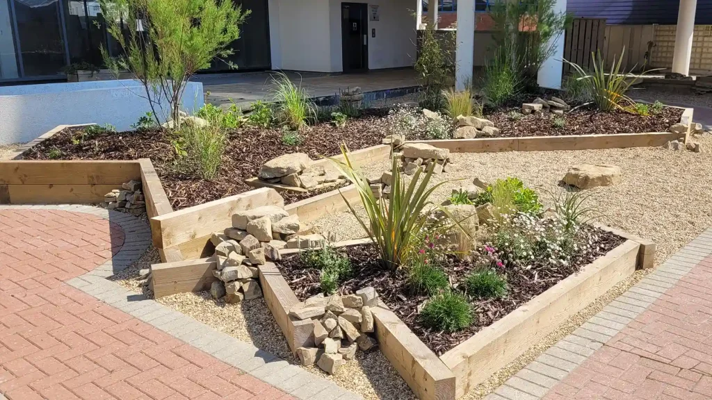 Sleeper planted area with planting and clusters of rocks from Horsham stone.