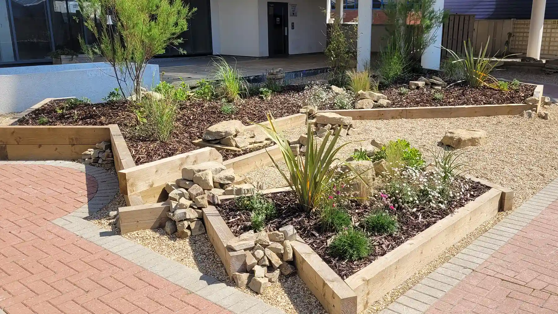Sleeper planted area with planting and clusters of rocks from Horsham stone.
