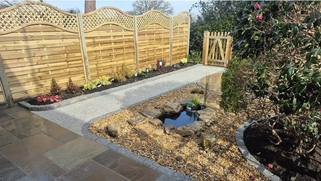 Landscaped back garden with arched lattice top fencing secured between concrete posts and gravel boards.