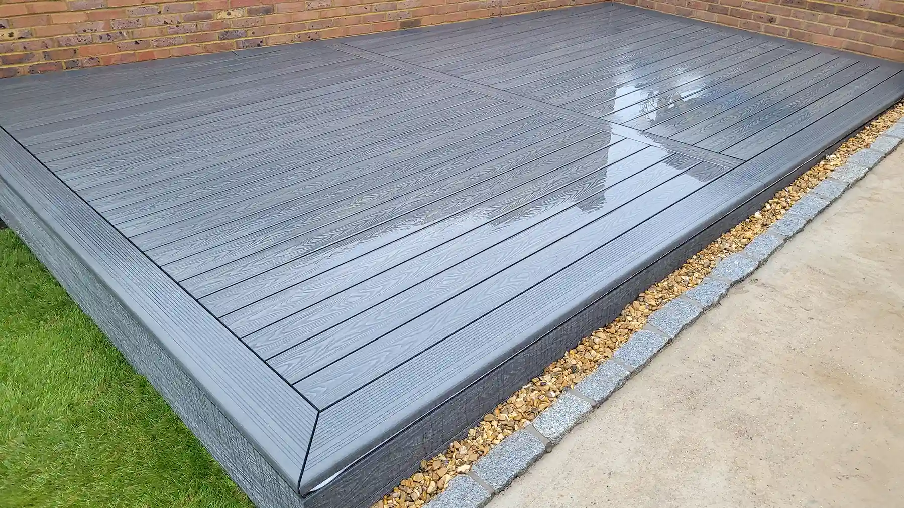 Grey composite decking with picture framing edge boards.