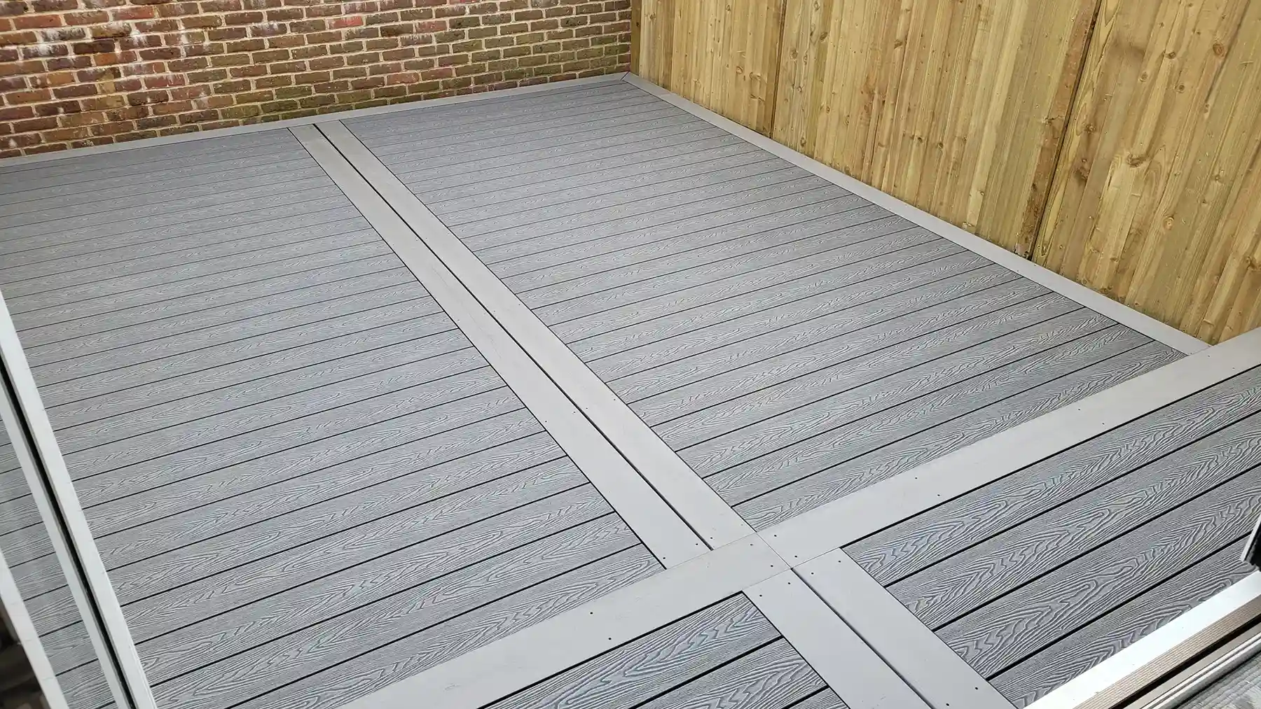 Grey grain effect composite decking with steps.
