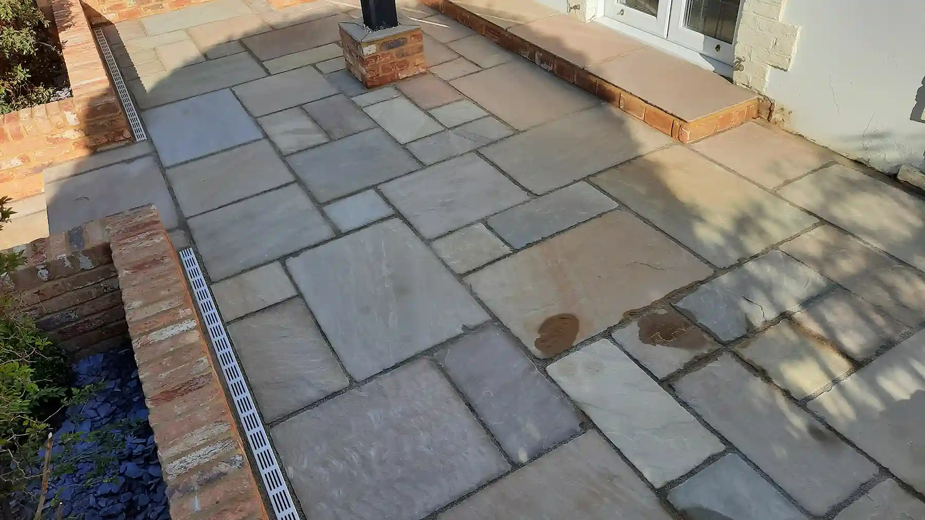 Raj green tumble patio with old farmhouse brickwork.