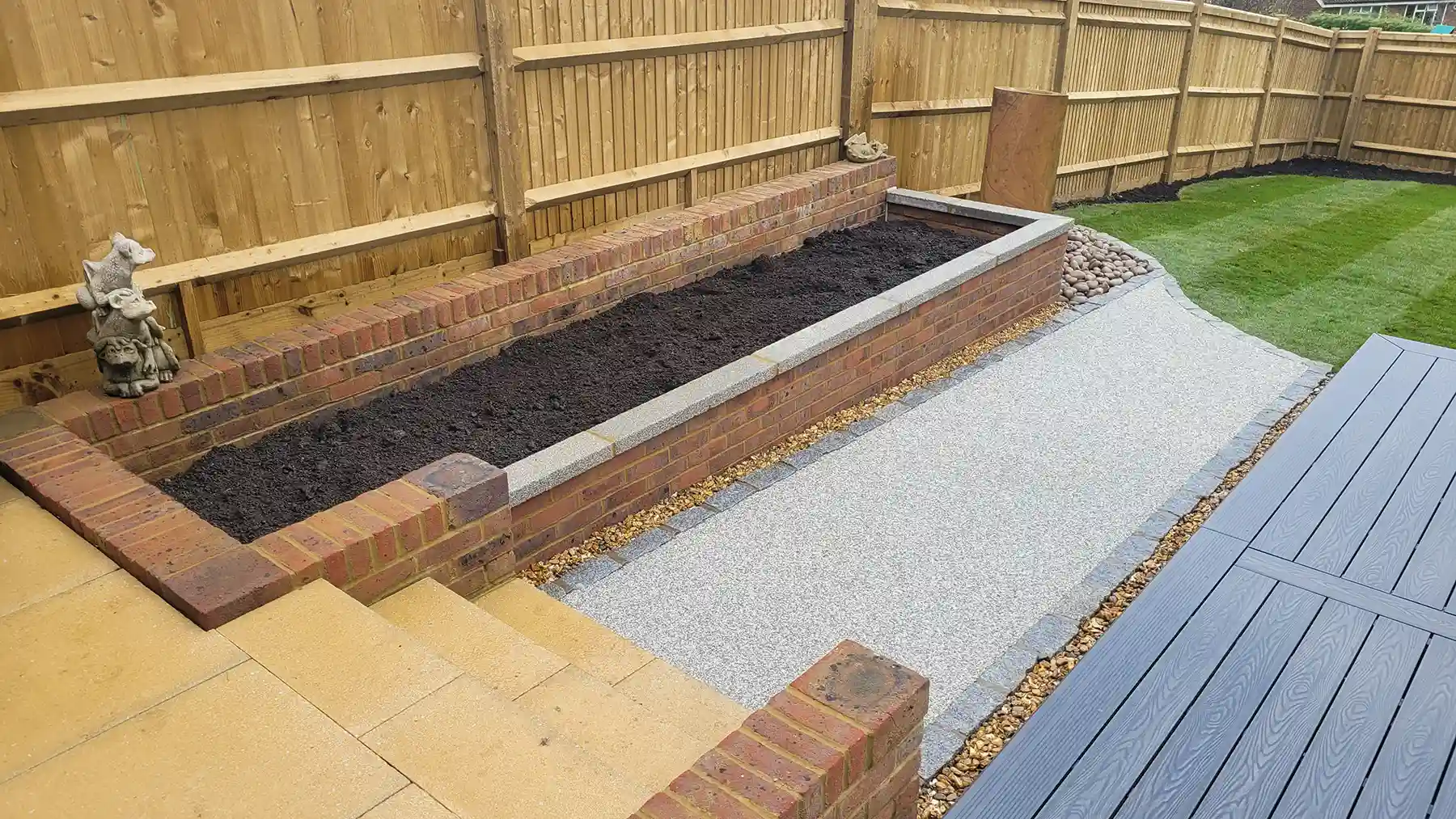 Resin bound pathway with granite edging leading from the house steps to the grass lawn.