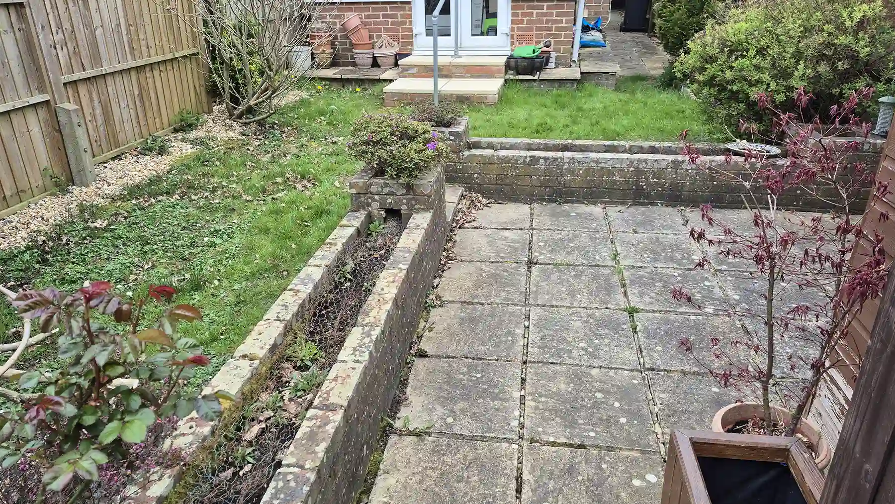 Old concrete patio area in a small garden.