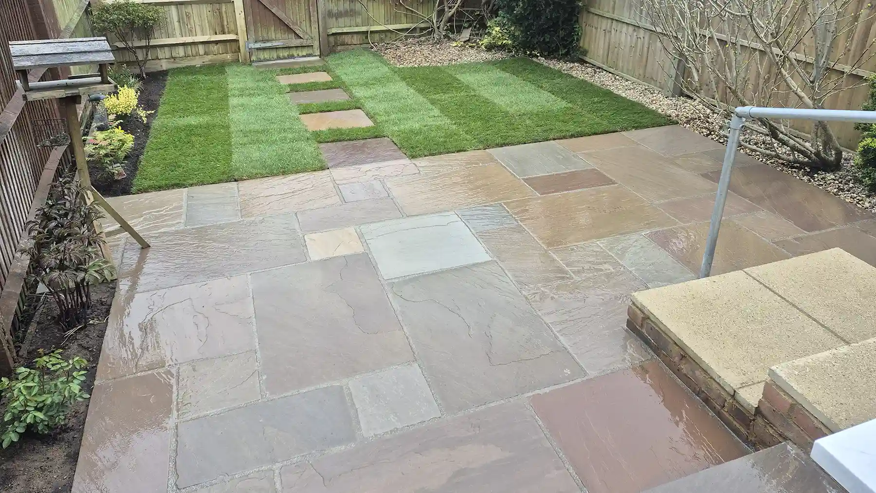 Small garden makeover incorporation a new raj blend sandstone patio with new lawn.