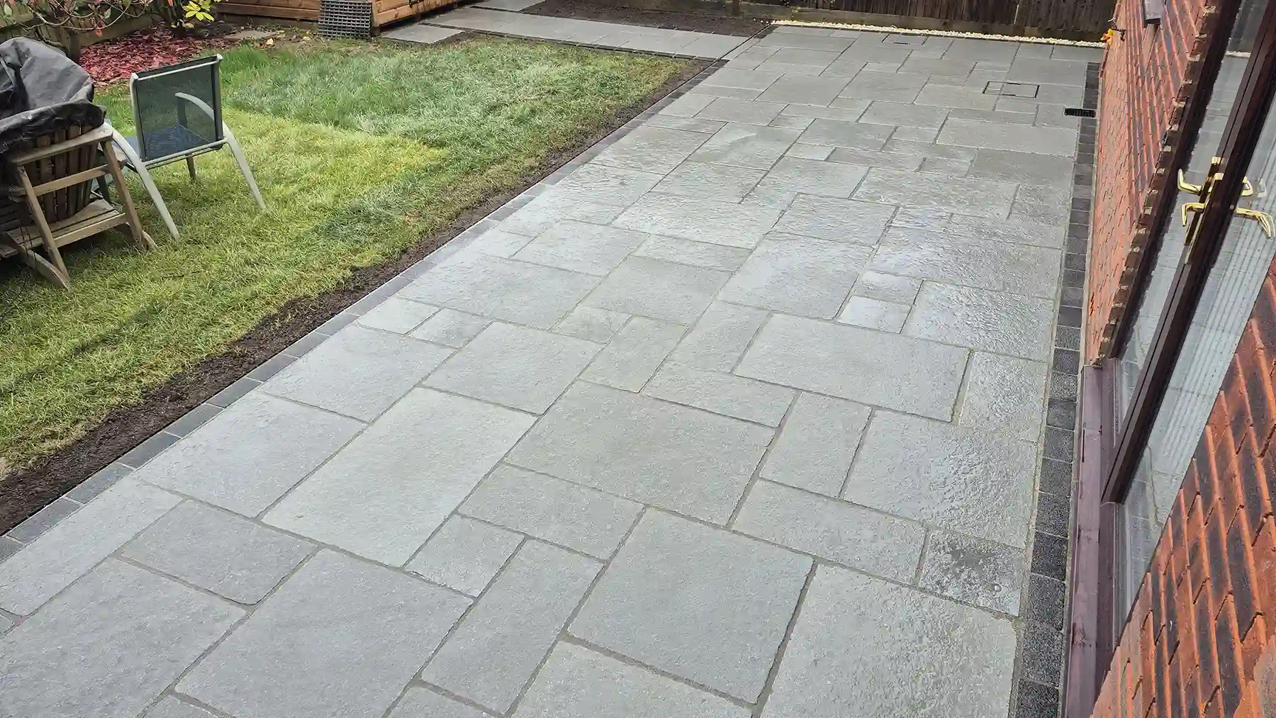 Antique grey limestone patio and pathway with dark granite edging.