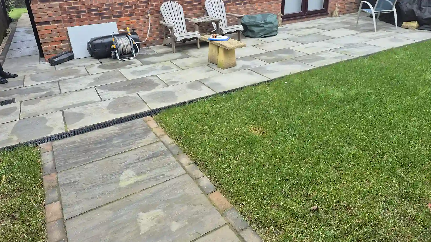 Old grey sandstone patio with pathway from the gate to the shed.
